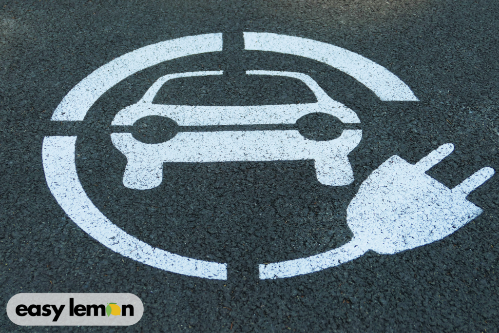 Electric vehicle charging symbol on pavement representing Jeep 4xe battery concerns related to Understanding Your Jeep Fire Recall Lemon Law Rights.