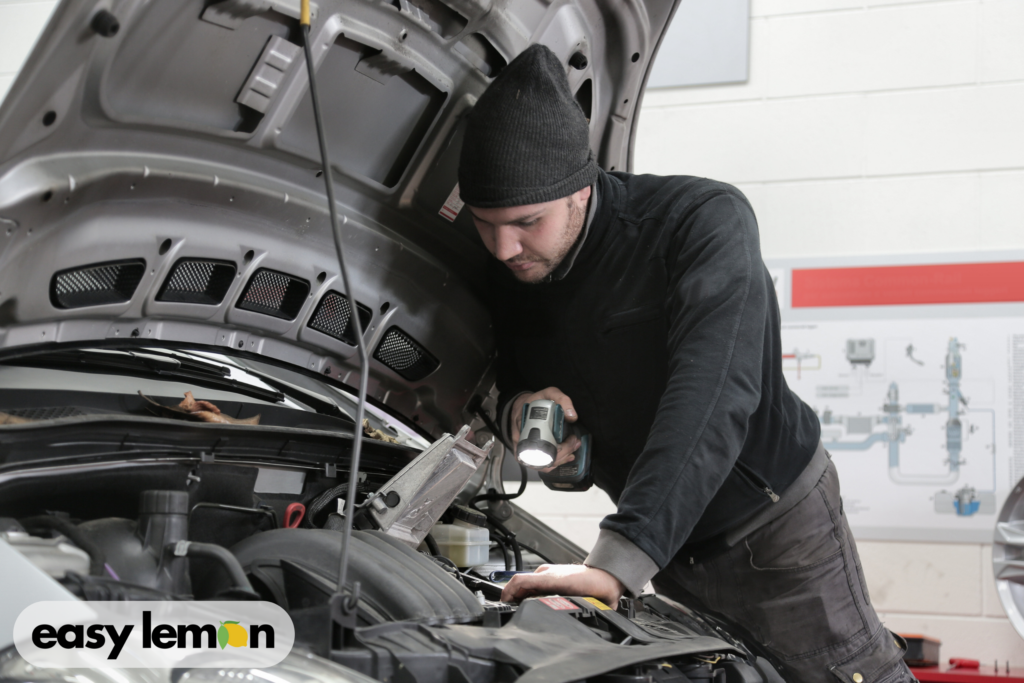 Mechanic inspecting a Ram truck engine to illustrate defects covered under the Texas Ram Lemon Law.